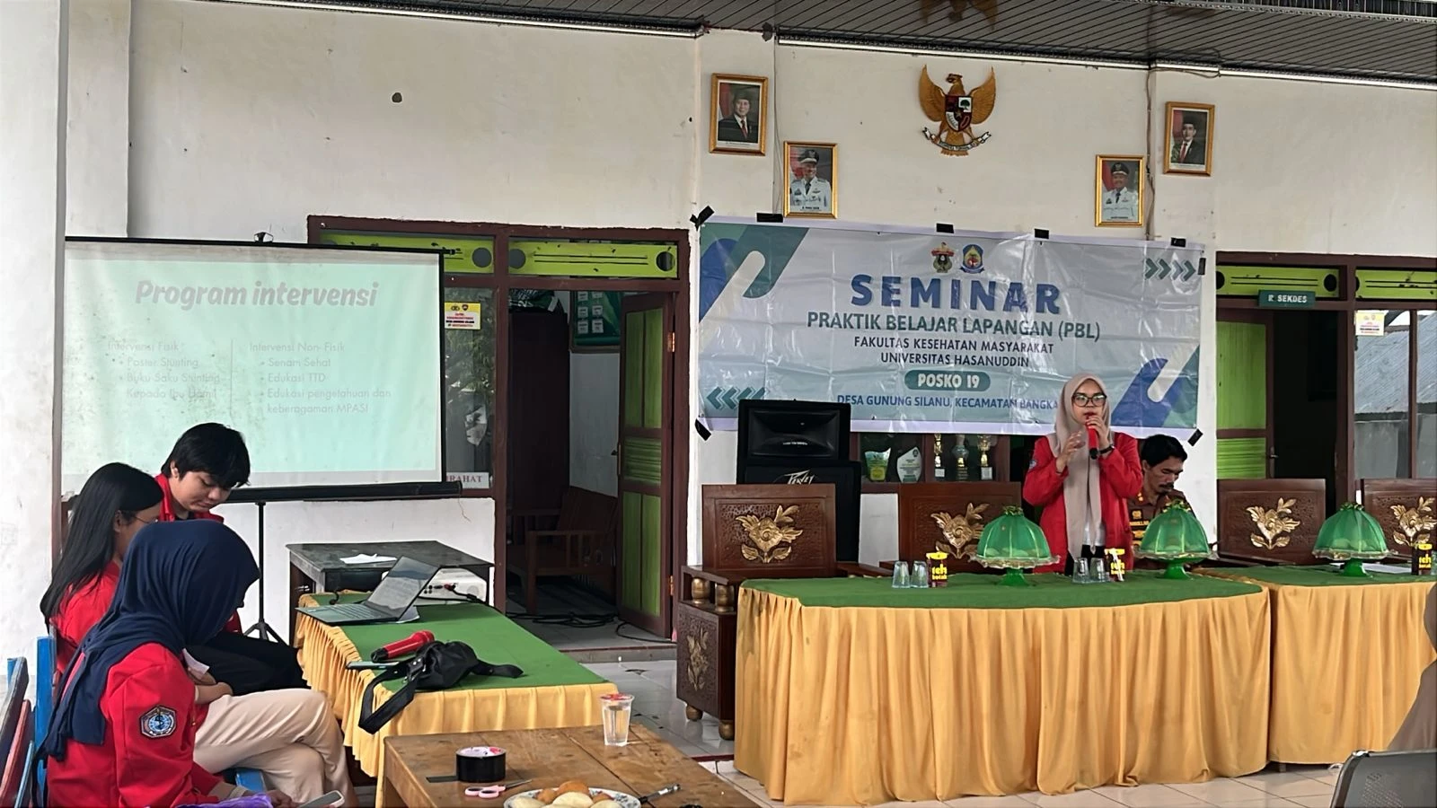 Koordinator Desa Posko 19, Rany Maharani, menjelaskan program evaluasi intervensi kesehatan selama seminar awal Praktik Belajar Lapangan (PBL) III FKM Unhas di kantor Desa Gunung Silanu, Jeneponto, Selasa (24/6/2025). Seminar ini bertujuan memperkenalkan anggota posko dan membahas program yang akan dijalankan selama 10 hari ke depan. Kredit:FKM Unhas.